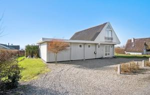 a white house with a garage on a gravel driveway at Gorgeous Home In Assens With Kitchen in Assens