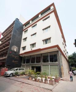 a white building with plants in front of it at Mayur Hotel in New Delhi