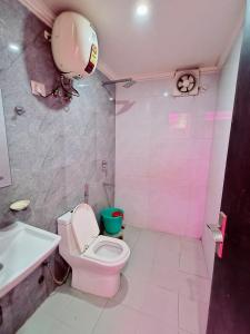 a pink bathroom with a toilet and a sink at hotel the paradise inn in New Delhi