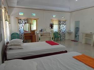 a bedroom with two beds and a table and chairs at Delima Cottage New Room in Langgur