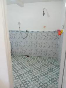 La salle de bains est pourvue d'une douche et de carrelage. dans l'établissement Delima Cottage New Room, à Langgur