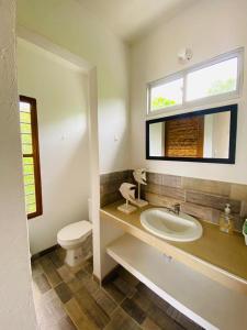 a bathroom with a sink and a toilet and a window at Cabaña cerca al Mar con Pisicina y AC en Tolú in Tolú