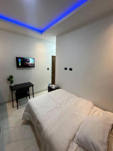 una camera con letto, scrivania e soffitto blu di Suite moderna “vieja kennedy” a Guayaquil
