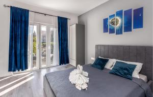 a bedroom with a large bed with blue curtains at Lovely Apartment In Jadranovo With Wifi in Jadranovo