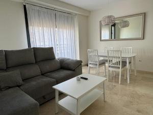 ein Wohnzimmer mit einem Sofa und einem Tisch in der Unterkunft Apartamento céntrico con terraza in Córdoba