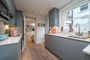 uma cozinha com um lavatório e uma janela em Niru Experience-Earl's Court Charm 2BD 2 BA em Londres