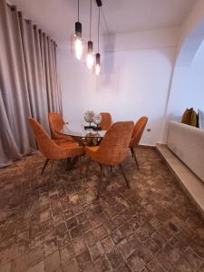a dining room with a table and chairs and a couch at Appartement Oxygène Marrakech Sun in Marrakesh