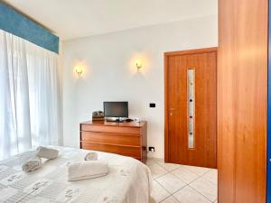 - une chambre avec un lit et une télévision dans l'établissement Hostdomus - Pietra Blu, à Pietra Ligure