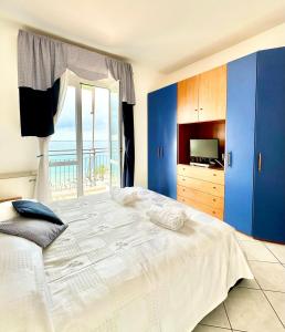 - une chambre avec un grand lit et une vue sur l'océan dans l'établissement Hostdomus - Pietra Blu, à Pietra Ligure