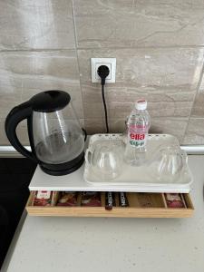 a counter top with a bottle of water and a blender at Amina in Tuzla +7 photos