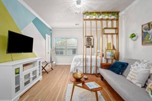a living room with a couch and a tv at Studio Heightspets! Walk To Restaurants in Houston