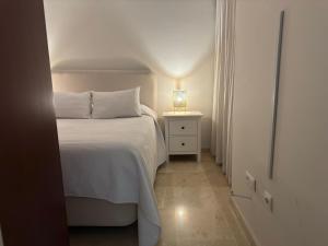 um quarto com uma cama com um candeeiro numa mesa de cabeceira em Apartamento céntrico con terraza em Córdoba