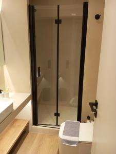 ein Bad mit einer Dusche und einem WC in der Unterkunft BlueMotion - TwinBedroomPortApartment N1 in Piräus