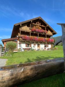 uma casa com flores na frente em Bauernhaus Durrahof em Steinberg am Rofan