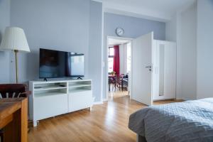 a bedroom with a white dresser with a flat screen tv at Alt-Berliner Eckkneipe - "Feuchte Ecke" in Berlin