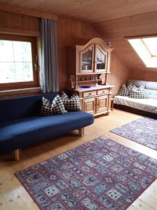 a living room with a blue couch and a mirror at Bauernhaus Durrahof in Steinberg am Rofan