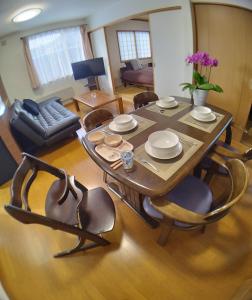 a dining table and chairs in a living room at Guest House Nishimiyanosawa in Teine