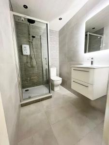 uma casa de banho com um chuveiro, um WC e um lavatório. em Seafront Apartment em Newcastle
