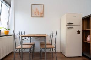 a kitchen with a table and chairs and a refrigerator at Cosy Nest - Apartment by Comfort Housing in Falkensee