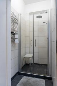 a glass shower with a stool in a bathroom at Cosy Nest - Apartment by Comfort Housing in Falkensee