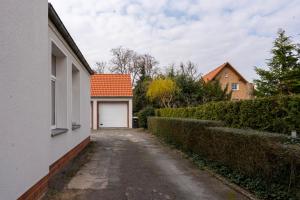 a driveway with a white garage and a house at Cosy Nest - Apartment by Comfort Housing in Falkensee