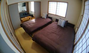 a hotel room with two beds and a mirror at Guest House Nishimiyanosawa in Teine