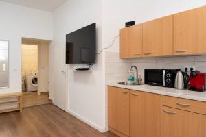 a kitchen with a sink and a microwave at NEST by Tendo Stay - Comfort Housing in Falkensee +8 photos