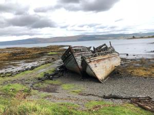two old boats sitting on a beach near the water at Argyll House Burnside in Salen