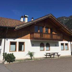 ein Gebäude mit einem Holzbalkon und einem Picknicktisch in der Unterkunft Agritur Fantelli Nicola 6 in Monclassico