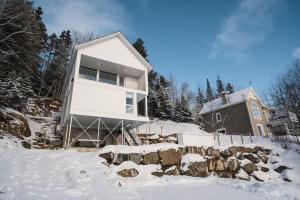 a house in the snow in front of a house at On The Rocks Ski in Ski out Spa in Saint Come