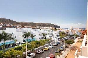 a city with cars parked in a parking lot at Ático Los Seres in Los Cristianos