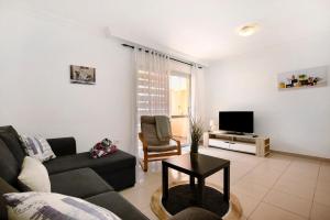 a living room with a couch and a tv at Ático Los Seres in Los Cristianos