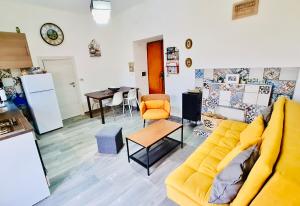 ein Wohnzimmer mit einem gelben Sofa und einem Tisch in der Unterkunft Casa Giulio in Capaccio-Paestum