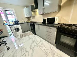 a kitchen with a stove and a microwave at Bethnal Green Rooms R2 in London