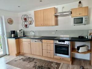 Una cocina con gabinetes de madera y una encimera negra. en Ferienwohnung Bauer, en Lam