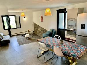 a living room with a dining table and a kitchen at Jolie maison avec piscine près d'un village typique in Monte