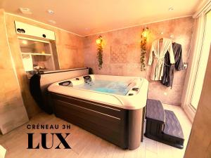 La salle de bains est pourvue d'une baignoire. dans l'établissement Lux, chambre spa privatif Valenciennes, à Aulnoy