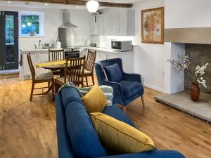 a living room with a blue couch and a table at Coldwell Street Cottage in Wirksworth