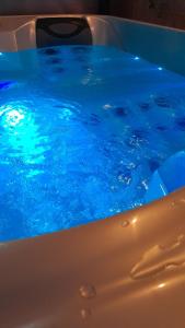a swimming pool with blue water at Lux, chambre spa privatif Valenciennes in Aulnoy +15 photos