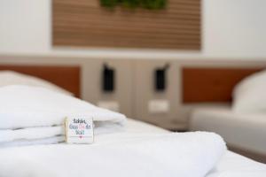 a sign on a bed with towels on it at Comfort Housing Apartments - Tendo Stay in Falkensee