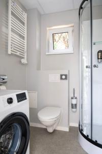 a bathroom with a toilet and a washing machine at Comfort Housing Apartments in Falkensee