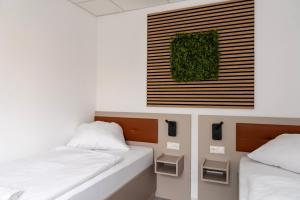 um quarto com duas camas e uma foto na parede em Comfort Housing Apartments em Falkensee