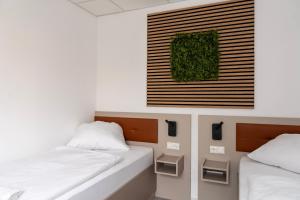 Zimmer mit 2 Betten und einem Bild an der Wand in der Unterkunft Comfort Housing Apartments in Falkensee
