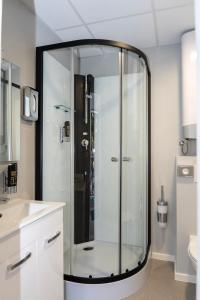 eine Glasdusche im Bad mit Waschbecken in der Unterkunft Comfort Housing Apartments in Falkensee + 28 Fotos