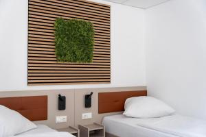 a bedroom with two beds and a green wall at Comfort Housing Apartments - Tendo Stay in Falkensee