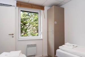 a room with two beds and a window at Comfort Housing Apartments - Tendo Stay in Falkensee +18 photos