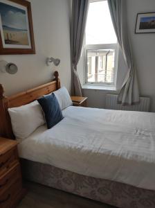 una camera da letto con un grande letto bianco e una finestra di 4 Bayview terrace a Bundoran