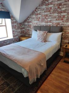 uma cama num quarto com uma parede de tijolos em 4 Bayview terrace em Bundoran
