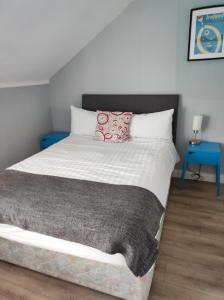 a bedroom with a large bed with a gray blanket at 4 Bayview terrace in Bundoran