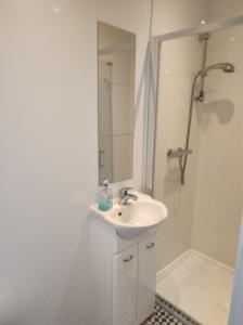 een witte badkamer met een wastafel en een douche bij 4 Bayview terrace in Bundoran
